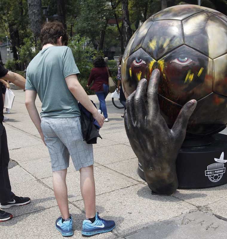 Personas observan el balón "Rode Duivels" intervenido por la artista mexicana Tere Muñoz. La afición mexicana es una de las que más interés ha demostrado por los boletos de Rusia 2018. (Foto Prensa Libre: EFE)