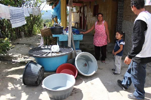 Los baldes de esta familia están vacíos, porque el agua no llega desde hace tres meses.