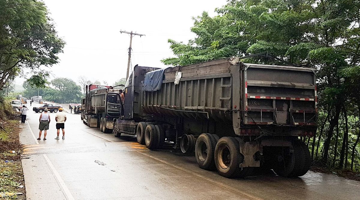Unos 40 camiones permanecen parqueados en El Estor, Izabal, por medida de protesta tomada por transportistas. (Foto Prensa Libre: Dony Stewart)