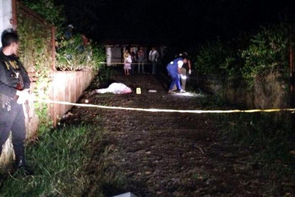 Autoridades resguardan el área donde murió baleado Tránsito Soto García, en San Andrés Villa Seca. (Foto Prensa Libre: Rolando Miranda)