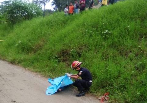 Un bombero inspecciona el cadáver de la fémina atacada en la ruta a Chinautla. (Foto Prensa Libre: CBM)