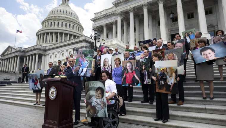 El senador demócrata por Nueva York, Chuck Schumer (en el atril) junto con otros senadores portan fotografías de aquellos pacientes se verían afectados por la reforma en la ley de Sanidad. (Foto Prensa Libre: EFE)