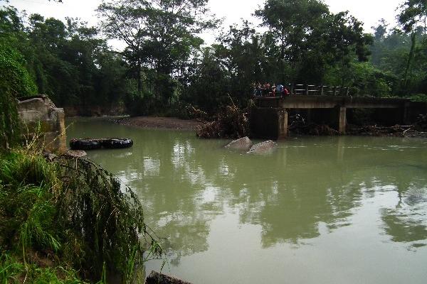 Vecinos observan la parte del puente que fue arrastrada por el río Xula, en Catarina, San Marcos.