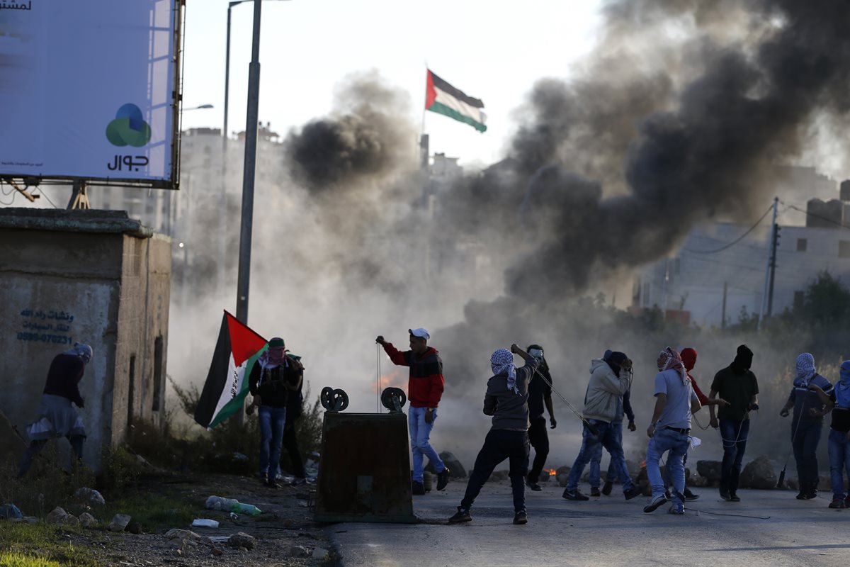 Palestinos lanzan piedras cont ra las fuerzas de seguridad israelíes. (Foto Prensa Libre: AFP).