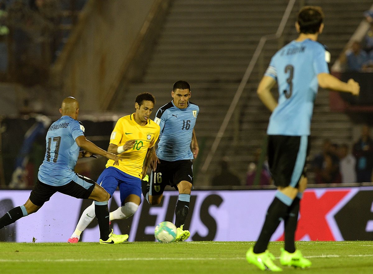 Neymar conduce la pelota en medio de los rivales de Uruguay.