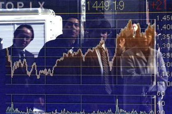 Peatones se ven reflejados en índices de la bolsa de Tokio (Foto Prensa Libre: Agencia AFP)