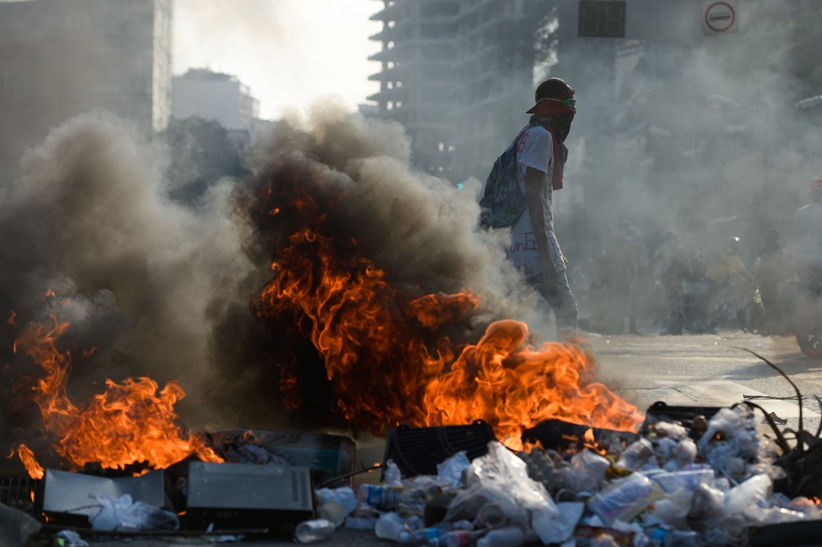Manifestantes chocan con la Policía, en Caracas. (Foto Prensa Libre: AFP)