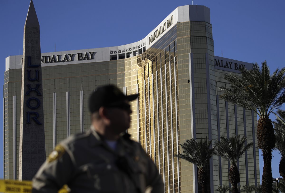 FILE - In this Tuesday, Oct. 3, 2017 file photo, a Las Vegas police officer stands by a blocked off area near the Mandalay Bay casino in Las Vegas. On Sunday, Oct. 1, Stephen Paddock opened fire on the Route 91 Harvest Festival killing dozens and wounding hundreds. Paddock spent hours in casinos. and was known for betting big on video poker and staring down fellow gamblers. There is no indication, though, that any particular grievance set him off. But details that have surfaced so far about the one-time IRS agent and son of a notorious bank robber, are clues, at least, to his mindset. (AP Photo/John Locher, File)