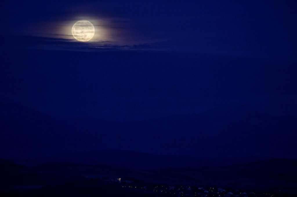 La primera luna llena del invierno astronómico, que comenzó la pasada noche, se eleva sobre la llanada Alavesa y el monte Aratz,  vista desde la cima del monte Olarizu, en Vitoria, al norte de España.