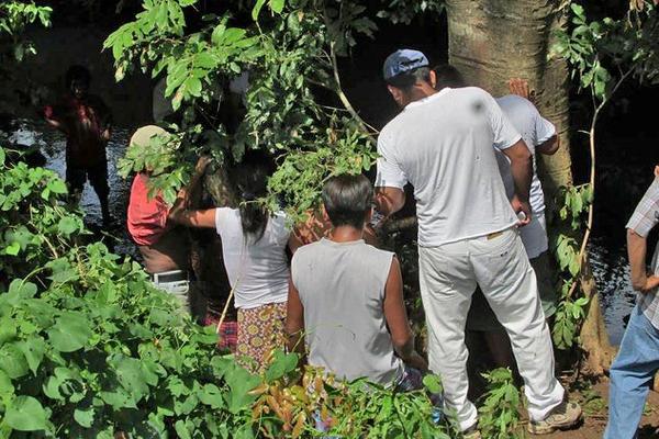 Vecinos observan el cadáver de Bartolo López García, quien fue encontrado en un río, en Malacatán. (Foto Prensa Libre: Cortesía)