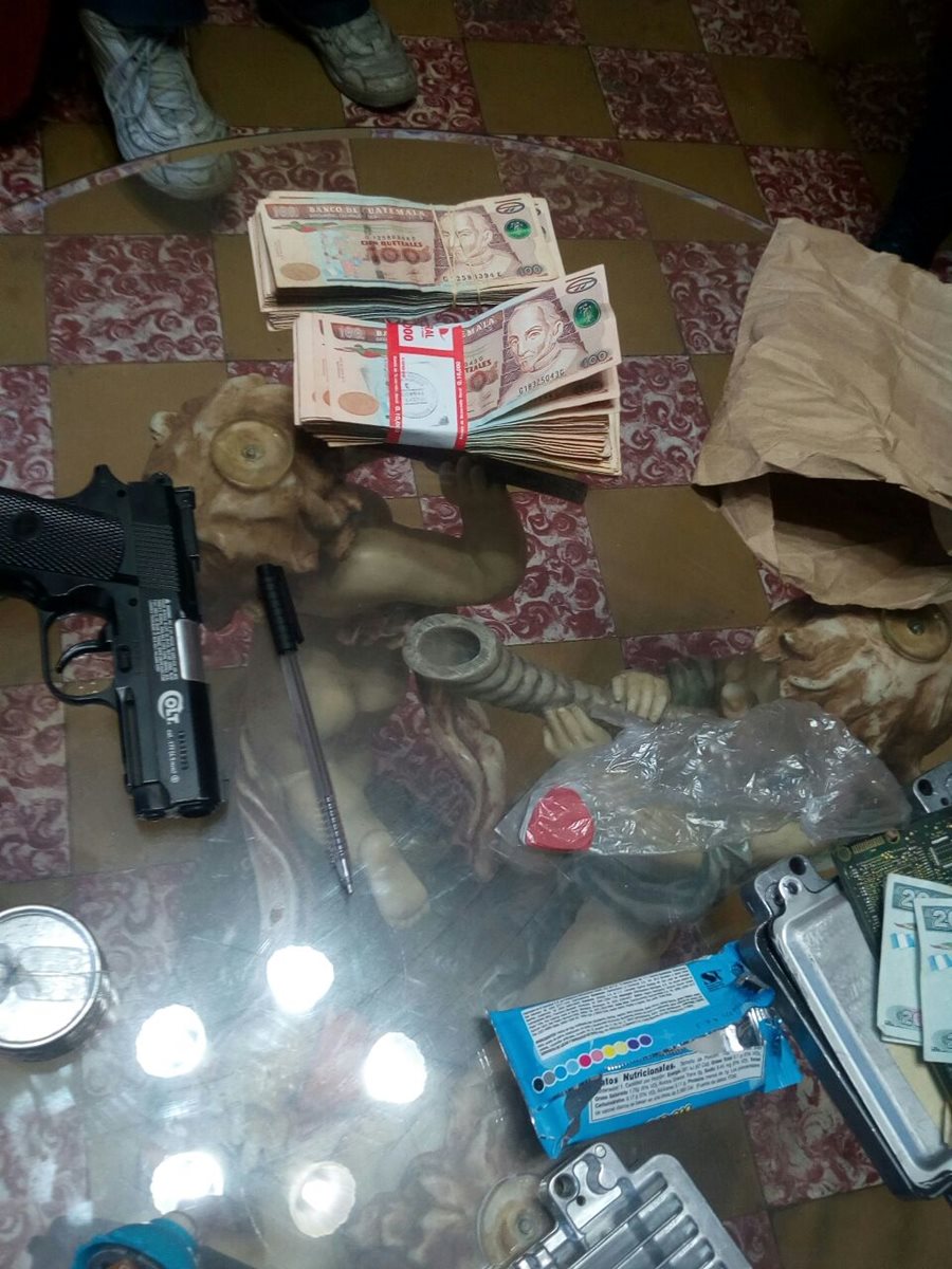Dinero y un arma localizada durante allanamientos contra extorsionistas en Mixco. (Foto Prensa Libre: PNC)