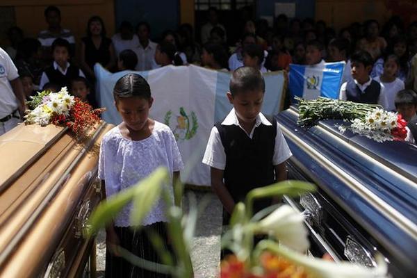Compañeros de estudios de los niños asesinados participaron en las honras fúnebres en la escuela donde ocurrió el ataque en Tactic, Alta Verapaz. (Foto Prensa Libre: EFE)