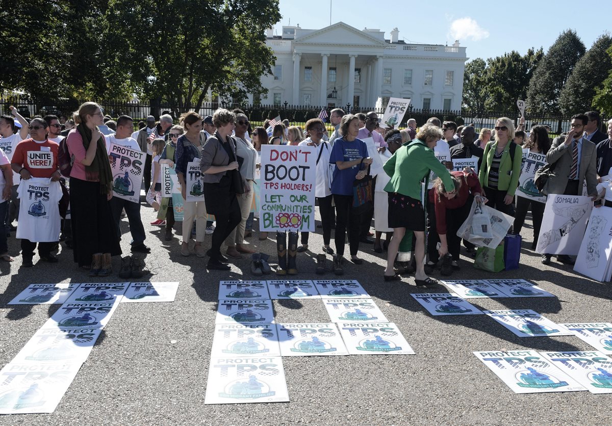 Manifestantes sostienen banderas EEUU y centroamericanas gritan consignas bajo el lema "Salvemos TPS" frente de la Casa Blanca en Washington.(Foto Prensa Libre:EFE).