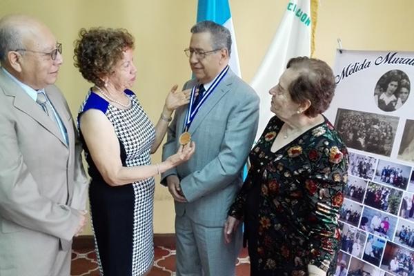 Olga de  Mendizábal entrega la Orden Mélida Muralles de Close a Enrique Godoy Durán.  Con ellos, Cecilio Baeza y Sonia Aguilera, presidenta de la AGG.  (Foto Prensa Libre: Edwin Castro)