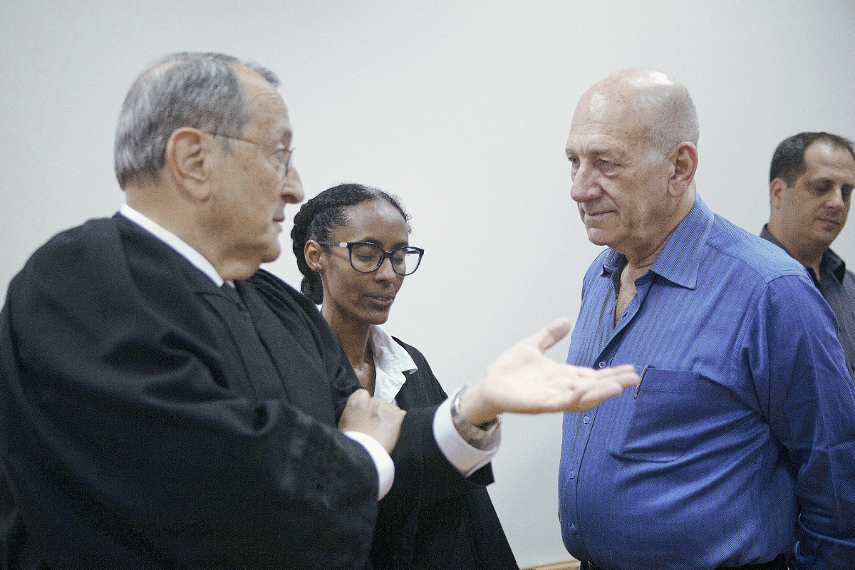 El ex primer ministro israelí Ehud Olmert (dcha) conversa con sus abogados en los juzgados en Jerusalén, Israel. (Foto Prensa Libre:EFE)