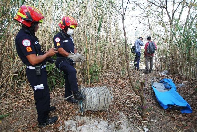 Bomberos Municipales a la orilla del barranco donde fue encontrado el cuerpo de una mujer. (Foto Prensa Libre: Érick Ávila)