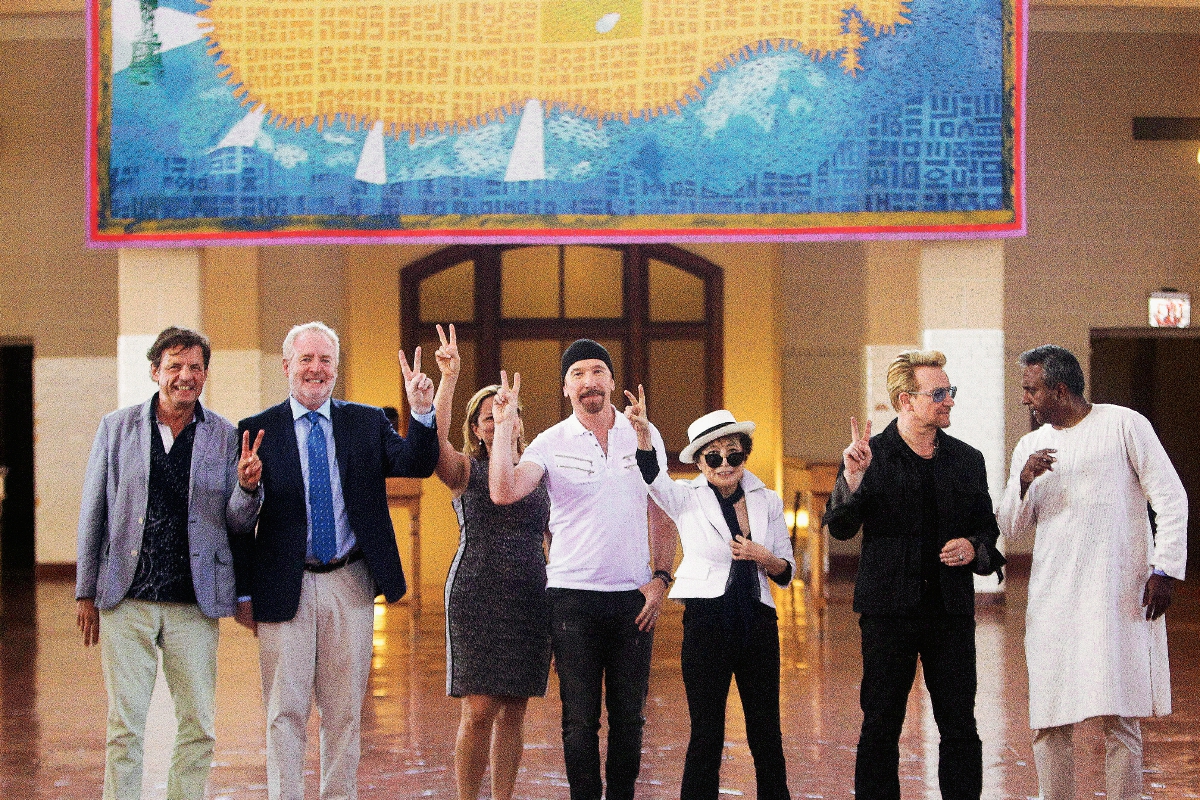 Bono, segundo de la derecha, vocalista de la banda irlandesa U2, desvela en Manhattan, Nueva York, junto a Yoko Ono, viuda de John Lennon, un tapiz de la isla de Manhattan en forma de submarino amarillo, como homenaje a John Lennon. (Foto AP)