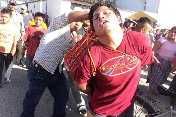Vecinos de San Miguel Chicaj, colocan piedras en la caja que carga Héctor López Jerónimo, presunto violador. (Foto Prensa Libre: Carlos Grave)