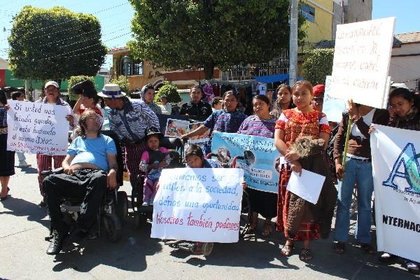Personas con  discapacidad y familiares   portan carteles para exigir inclusión social.