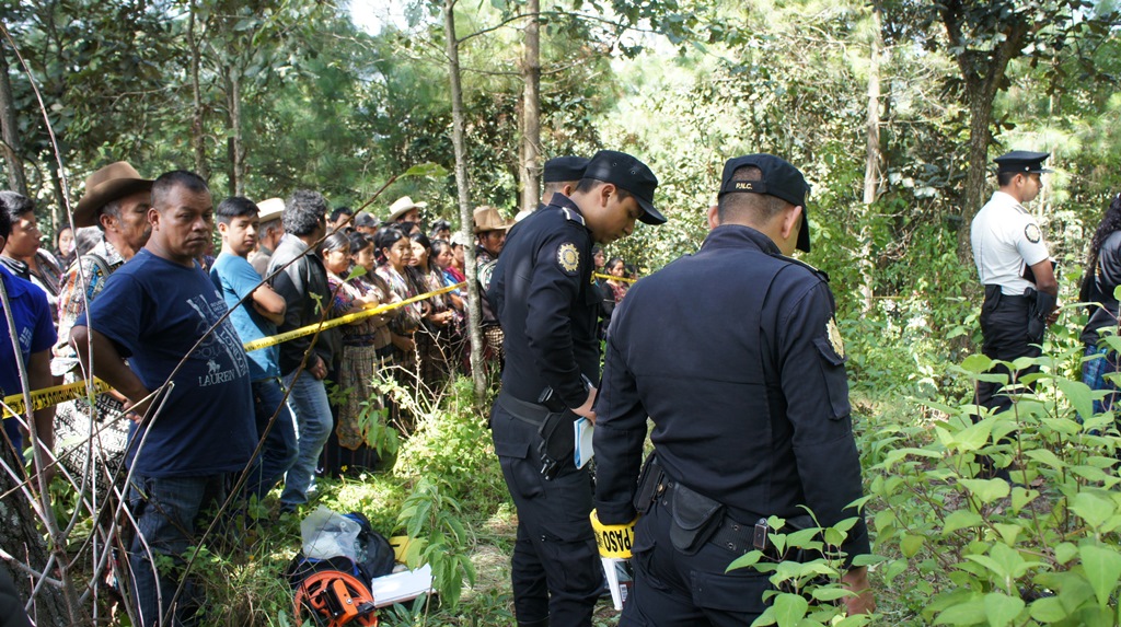 Autoridades policiales y vecinos observan cadáver de mujer, en la cabecera de Sololá. (Foto Prensa Libre: Ángel Julajuj)