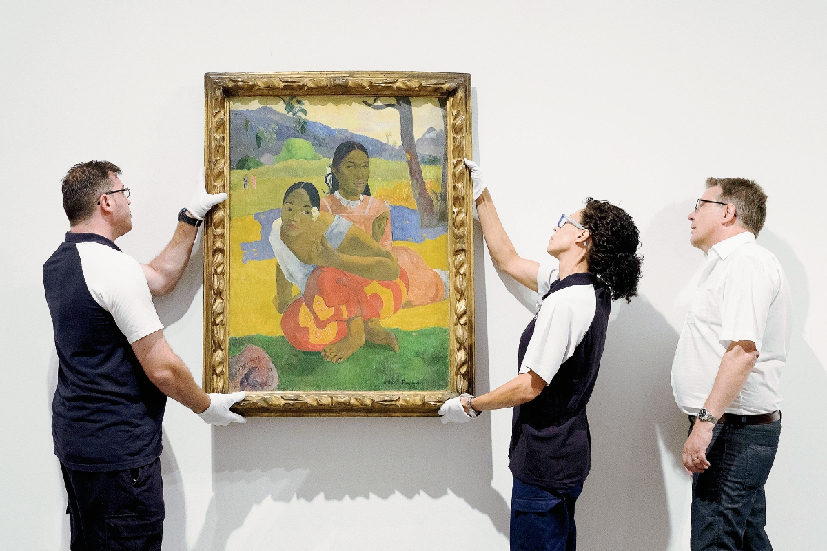 Dos empleados del Museo Reina Sofía instalan el cuadro de Paul Gauguin's "Nafea Ipoipo faa", la obra más cara vendida del mundo. (Foto Prensa Libre, AFP)