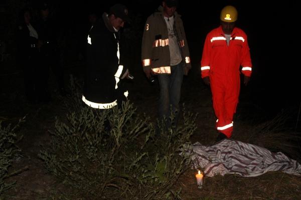Socorristas observan el cadáver de María Delia Palencia, quien murió al ser arrastrada por el río El Gavilán, en Mataquescuintla. (Foto Prensa Libre: Oswaldo Cardona)