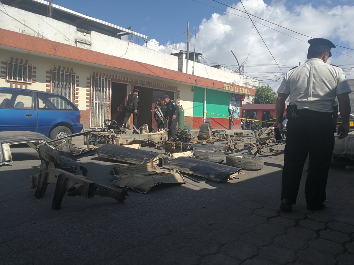 Un agente de la PNC resguarda las piezas de automóviles que fueron decomisadas. (Foto Prensa Libre: Fred Rivera).