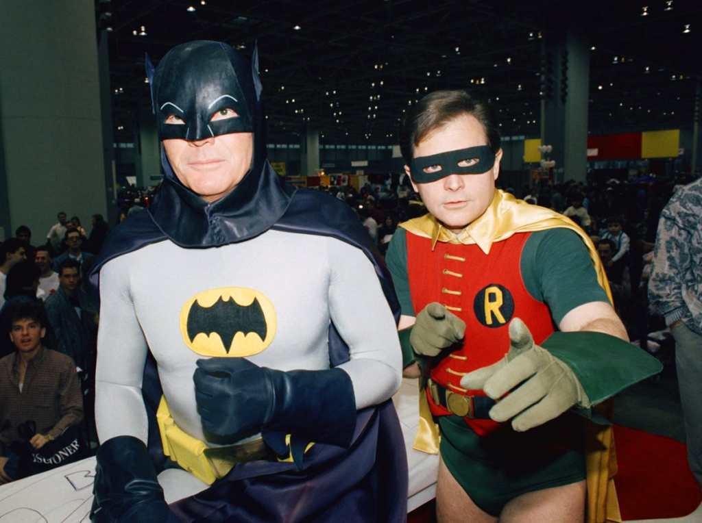 FILE - In this Jan. 27, 1989 file photo, actors Adam West, left, and Burt Ward dress as their characters Batman and Robin respectively during an appearance at the "World of Wheels" custom car show in Chicago. The actors are voicing their characters in an animated film, "Batman: Return of the Caped Crusaders," that will be released digitally on Oct. 11 and on Blu-ray on Nov. 1. (AP Photo/Mark Elias, File)