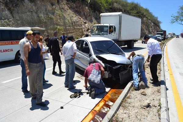 Curiosos observan el vehículo en el que resultó herido Maximiliano Peralta, en Sanarate. (Foto Prensa Libre: Hugo Oliva)