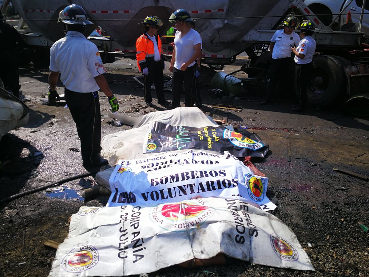 Bomberos observan los cuerpos de varias personas que perdieron sus vidas en el accidente