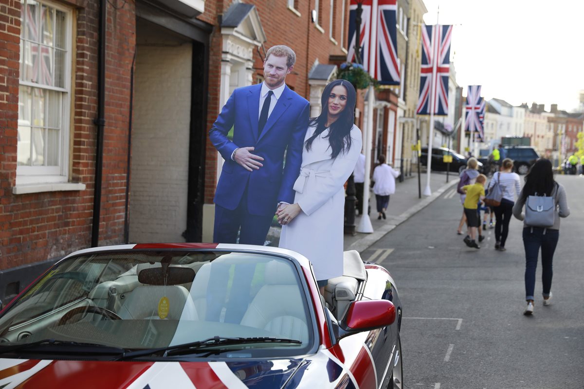 Cartones con la fotografía de Meghan Merkle y el príncipe Enrique han aparecido en las calles de Londres previo a la boda real (Foto Prensa Libre: AFP).