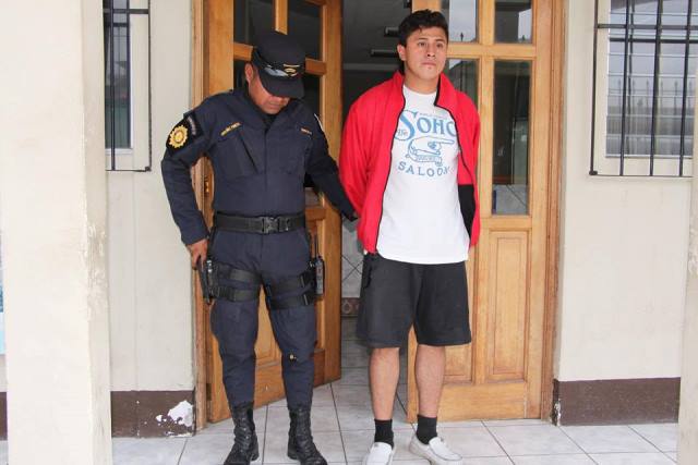 Edwin Geovanni Morales Echeverría es señalado de haber disparado a sus hermanos. El hombre es trasladado a un juzgado por un agente de la PNC. (Foto Prensa Libre: PNC)