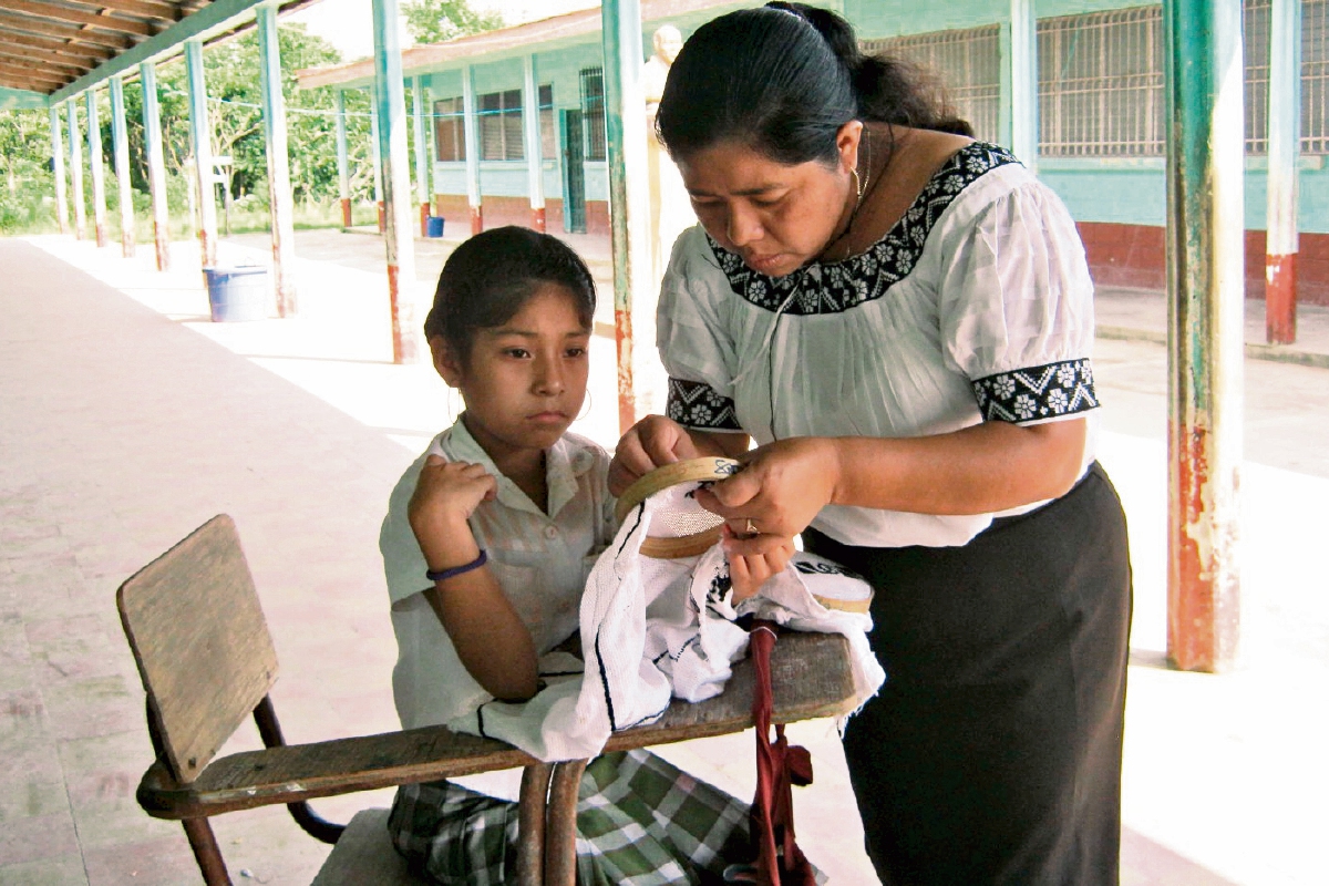 La maestra mopán, Aurelia Pop Chun, enseña sobre tejidos de esta cultura a estudiante de una escuela de San Luis, Petén.