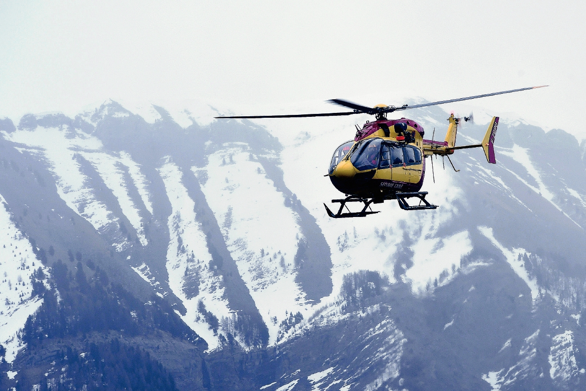 Un helicóptero sobrevuela los Alpes franceses, en busca de sobrevivientes. Los equipos de rescate suspendieron labores debido a la falta de visibilidad. (Foto Prensa Libre: AFP).