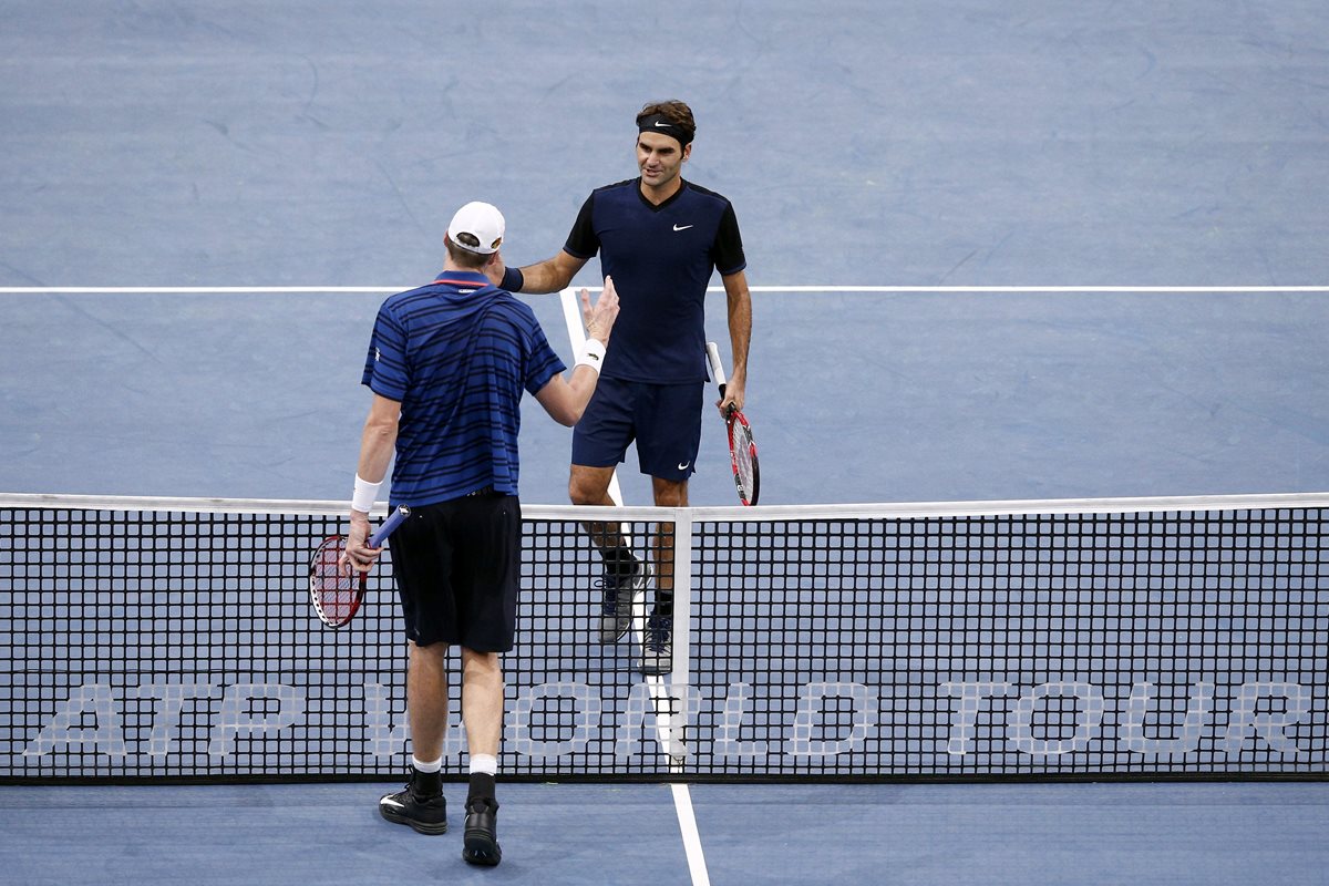 John Isner (i) saluda al suizo Roger Federer (d) tras vencerle en el partido de octavos de final del Masters 1.000 de París. (Foto Prensa Libre: EFE)