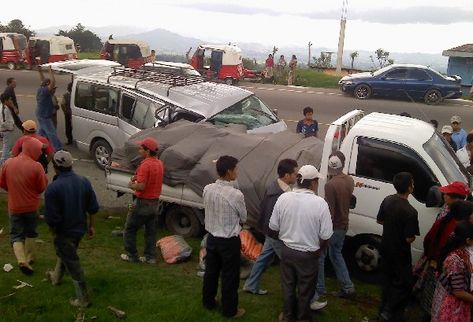 Curiosos observan  los  vehículos chocados.
