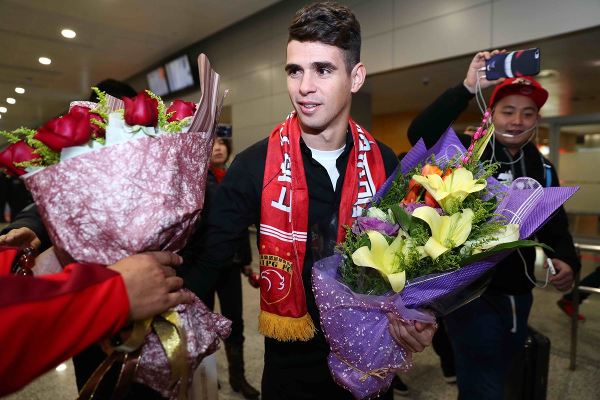 El futbolista brasileño Oscar es recibido por aficionados en el aeropuerto Pudong de Shanghai. (Foto Prensa Libre: AFP).