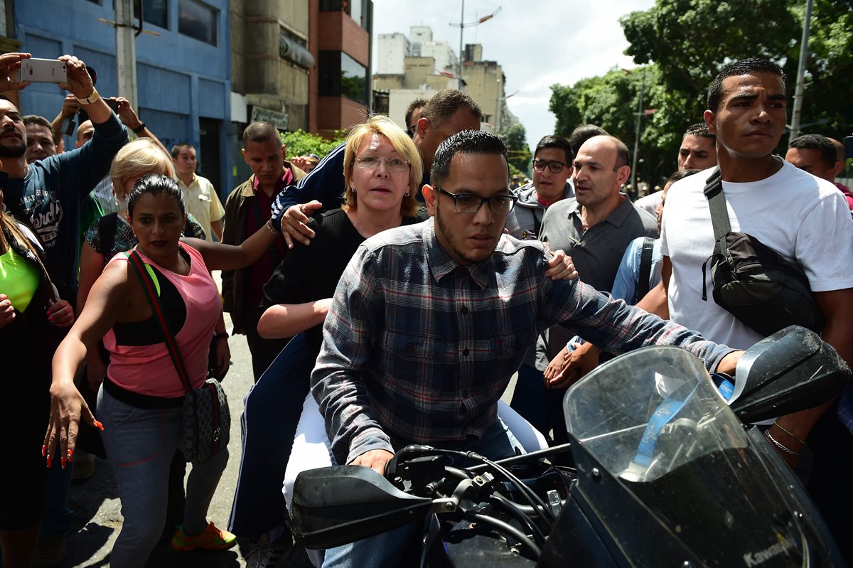 En una motocicleta tuvo que abandonar el edificio del Ministerio Público la hasta hoy fiscal general de Venezuela, Luisa Ortega. (Foto Prensa Libre: AFP)