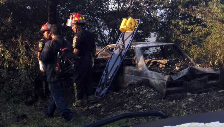 Bomberos Municipales Departamentales observan el vehiculo quemado en el kilómetro 105 ruta a las Verapaces. (Foto Prensa Libre: Hugo Oliva).