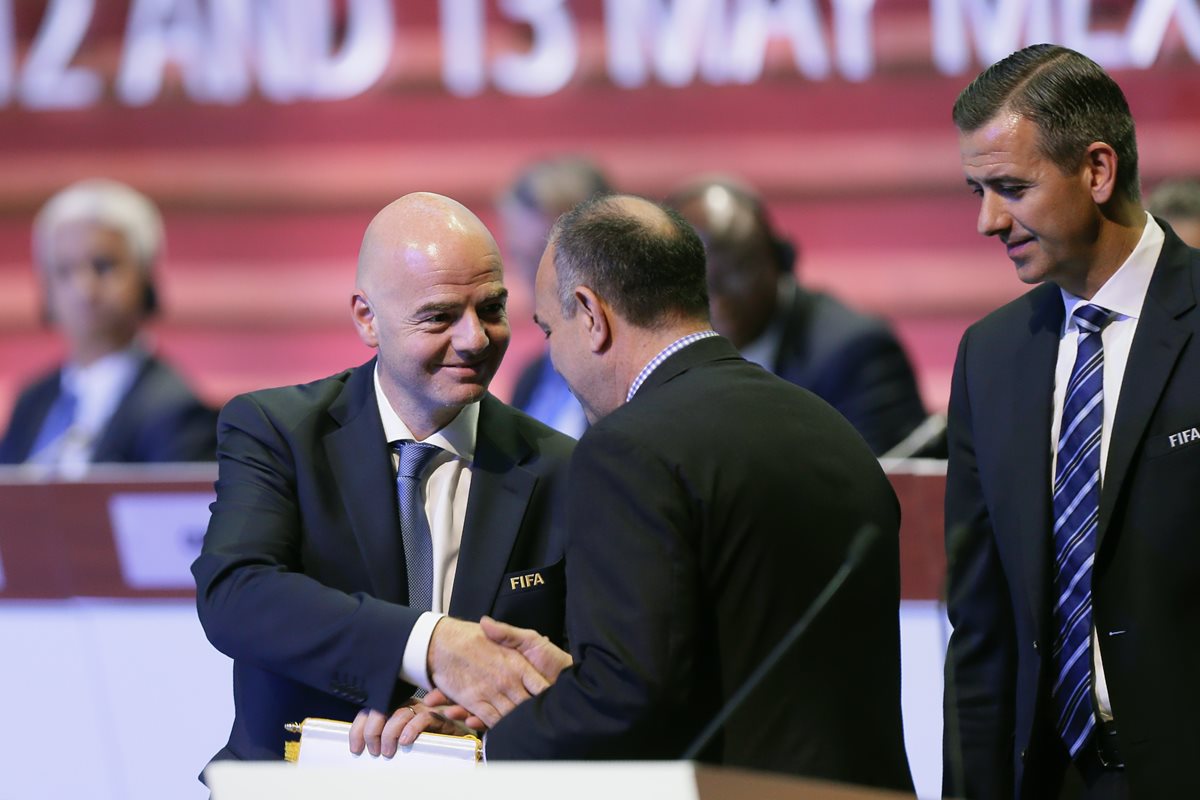 El presidente de la Fifa, el suizo Gianni Infantino (i), da la mano al presidente de la Asociación de Fútbol de Gibraltar Michael Llamas (c). (Foto Prensa Libre: AFP)