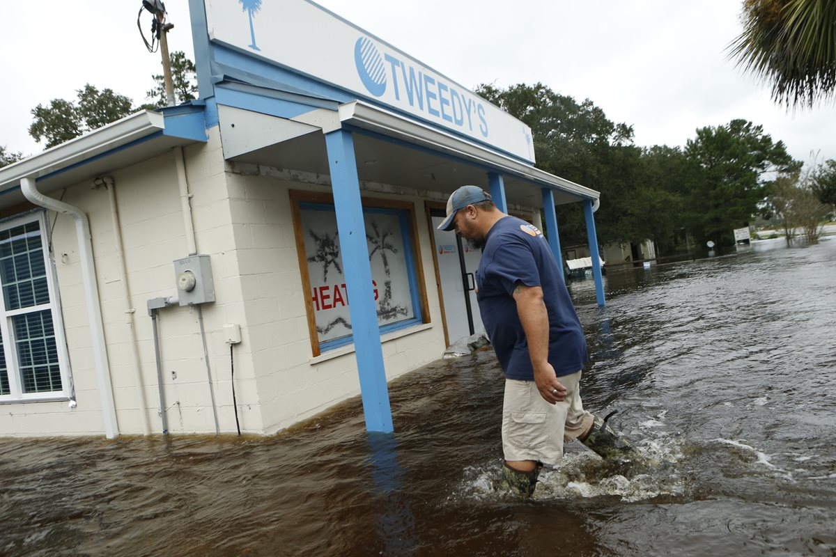 Un hombre camina en las calles inundadas de Carolina del Sur, luego del paso del huracán Matthew. (Foto Prensa Libre: AFP).