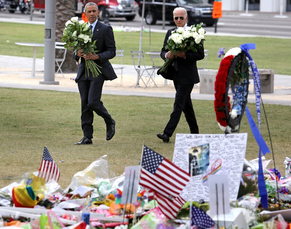 Obama (i) y Biden (d), llevan un arreglo floral en memoria de las víctimas. (Foto Prensa Libre: APF).