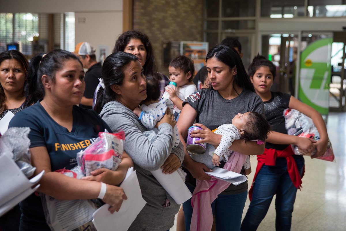 Madres inmigrantes con sus hijos caminan a un centro de socorro cercano de Catholic Charities, en McAllen, Texas. (Foto Prensa Libre: AFP)