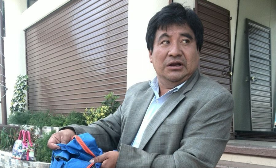 Caal muestra una de las mochilas con defectos de fabricación. (Foto Prensa Libre: Byron Vásquez)