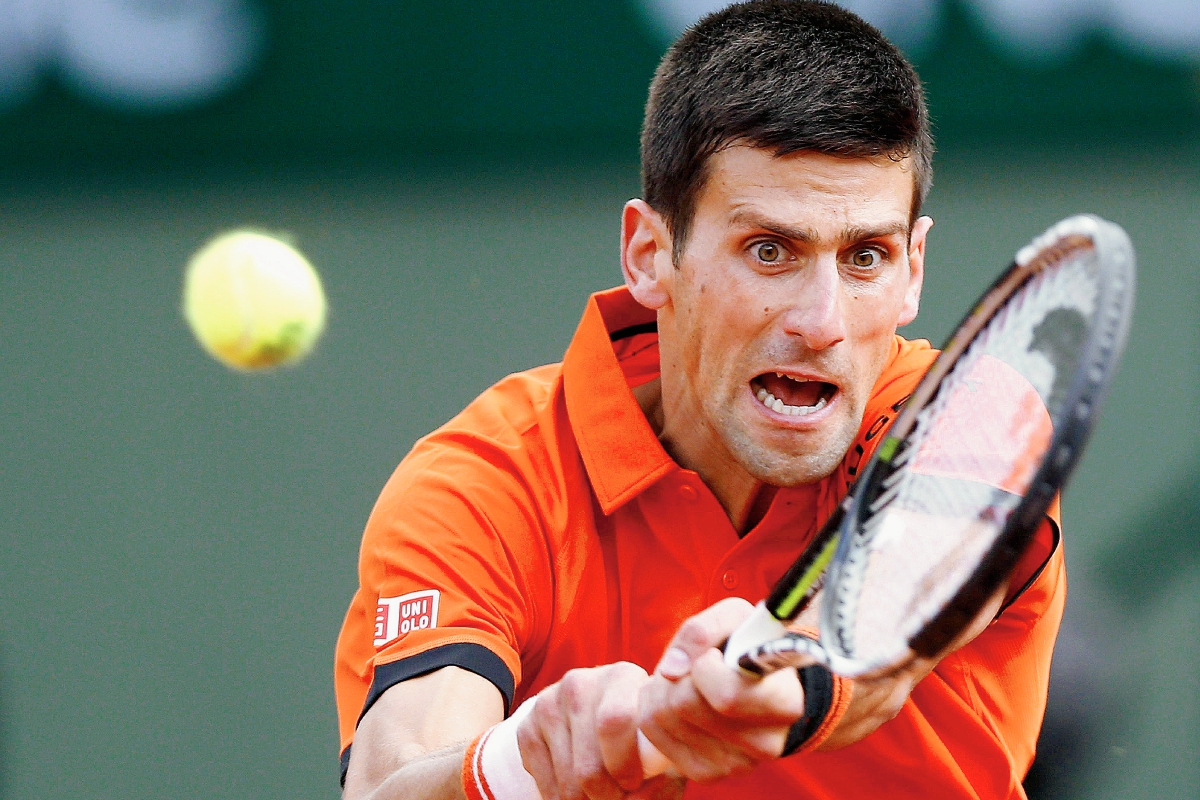 El tenista serbio Novak Djokovic devuelve una bola al finlandés Jarkko Nieminen, durante el partido de primera ronda de Roland Garros de este martes. (Foto Prensa Libre: EFE)