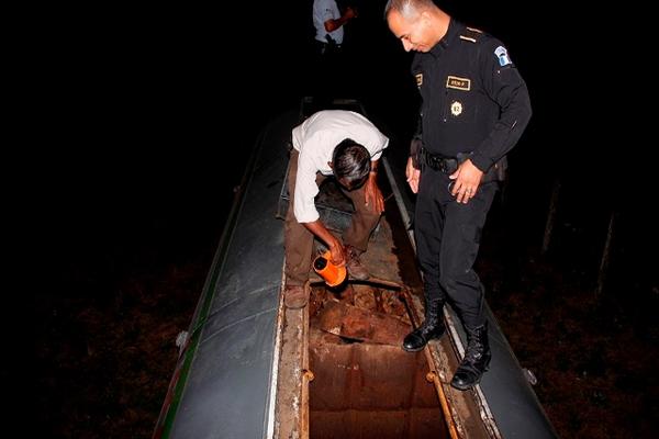 Investigadores inspeccionan el camión cisterna que contenía madera preciosa, en Poptún, Petén. (Foto Prensa Libre: Rigoberto Escobar)