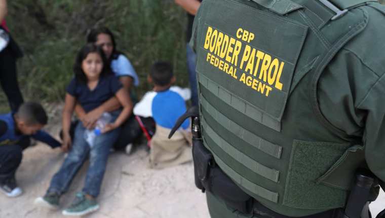Un guardia fronterizo vigila a una familia, recién detenida en la frontera sur de EE. UU. (Foto Prensa Libre: AFP)