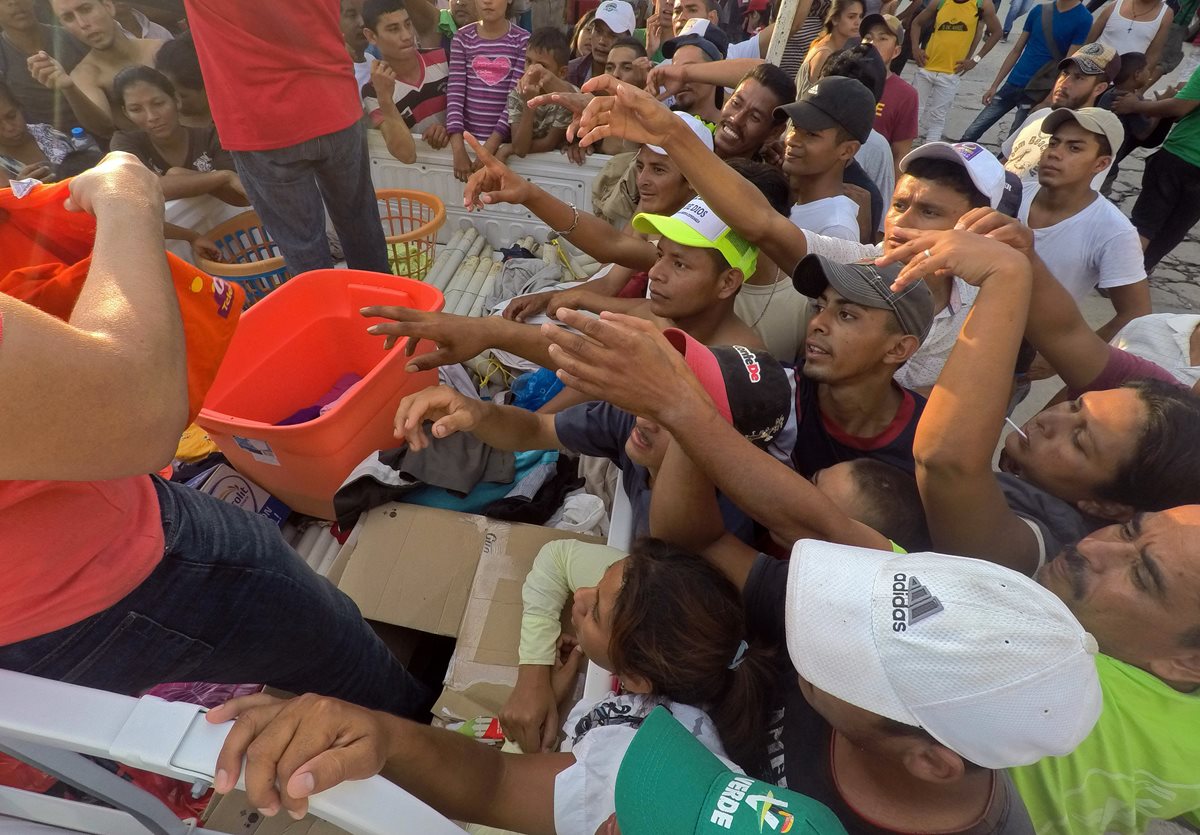 Migrantes hondureños reciben alimentos hoy en el municipio de Pijijiapan, en el estado de Chiapas, México. (Foto Prensa Libre: EFE)