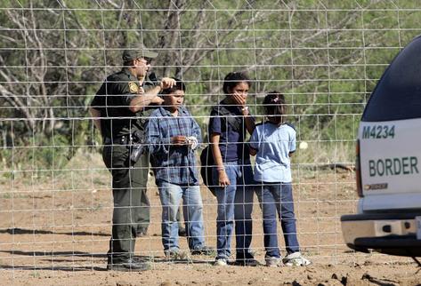 Un oficial de migración conversa con unos niños a las afueras de un albergue.  (Foto Prensa Libre: Canal 15).