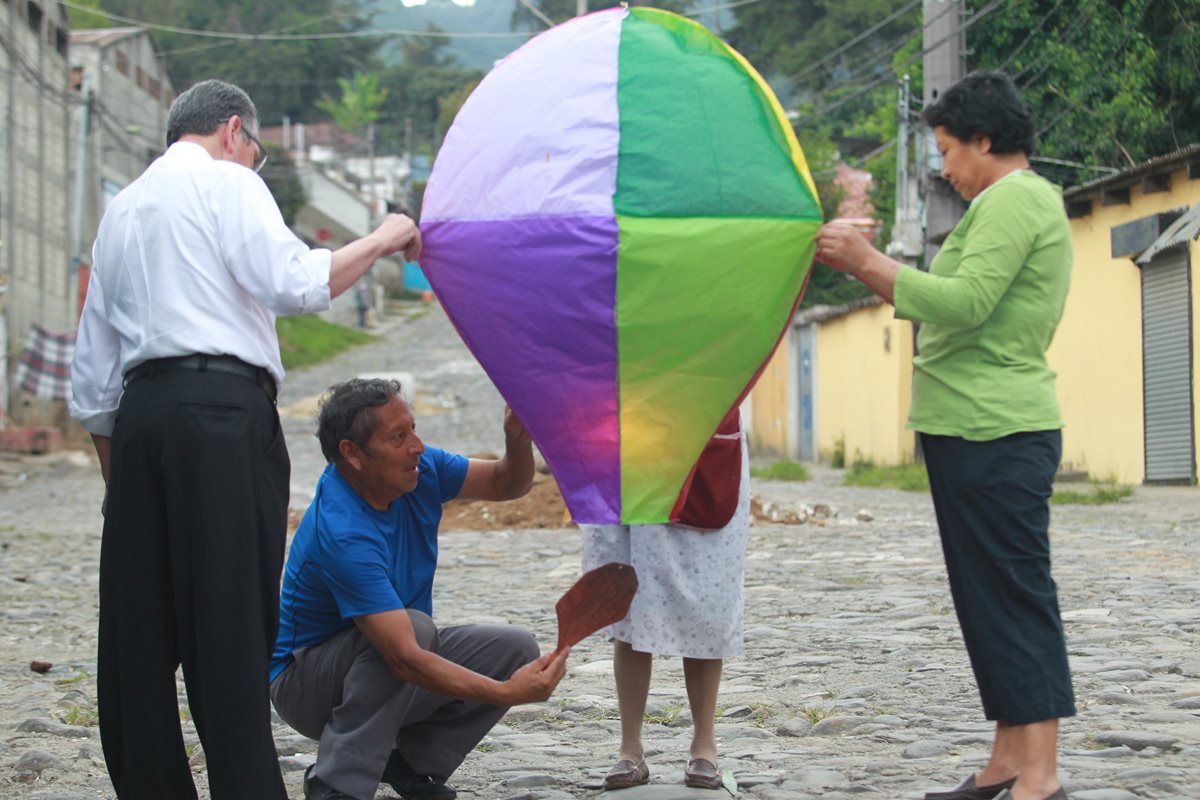 Marco Antonio Chacón Chinchilla (azul) es uno de los últimos artesanos que se dedica a la confección y elevación de globos de colores de papel de china, una tradición casi por completo olvidada. (Foto Prensa Libre: Estuardo Paredes)